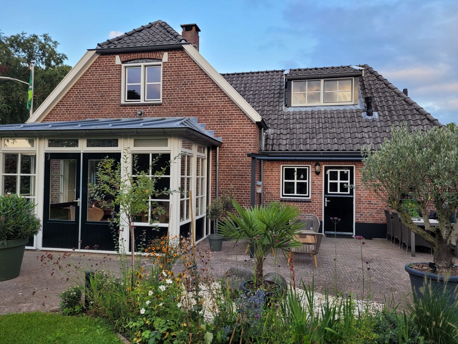 Woning van een klant met serre en tuin, waar alle ruiten door HR++ glas zijn vervangen