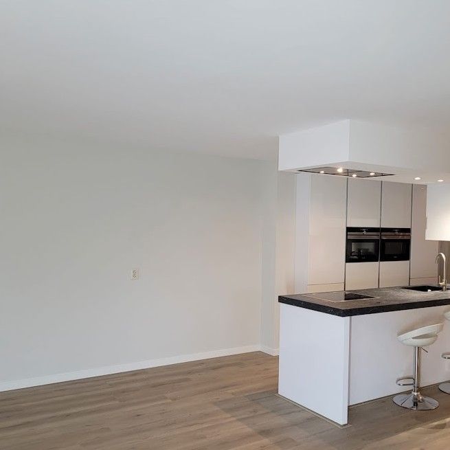 Witte woonkamer met open keuken